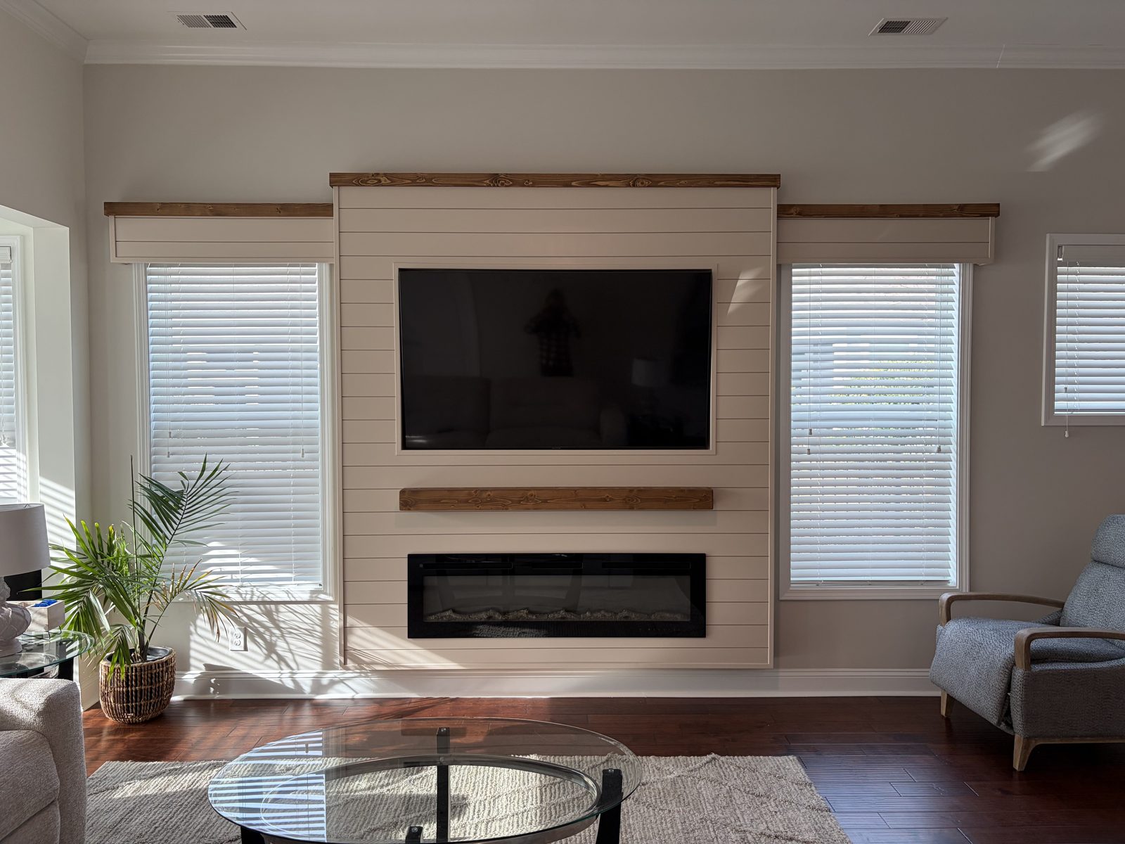 Cream shiplap fireplace and TV wall with a wood mantel, linear insert, and matching window valances