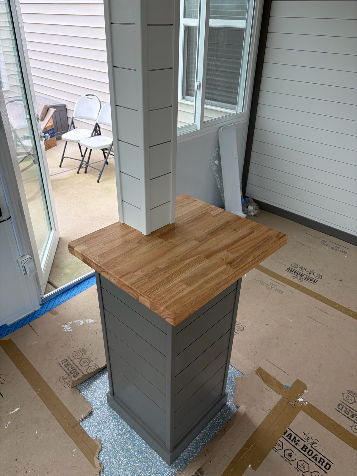 Butcher-block bartop built around a structural post, gray shiplap base and white shiplap wrap